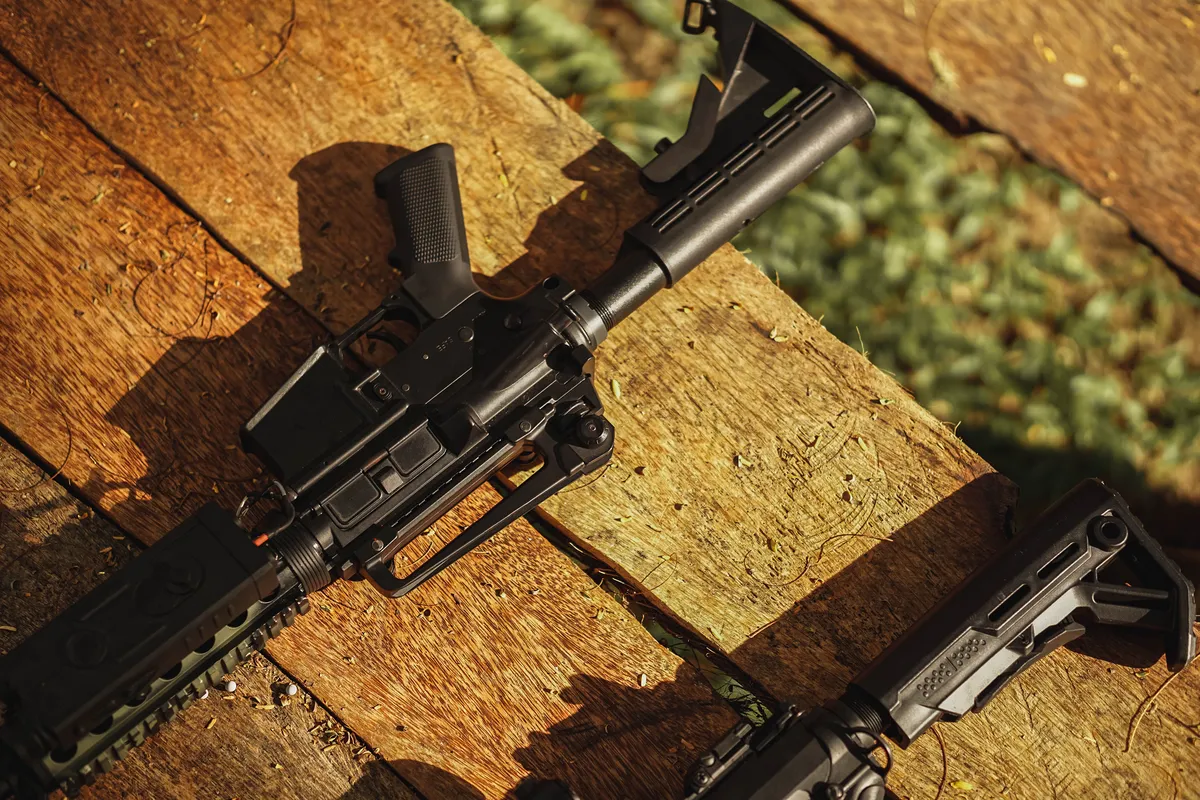 Karabiny AR15 leżące na drewnianym stole